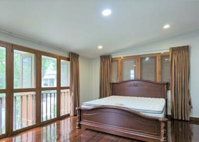 Spacious bedroom with large windows and wooden bed frame