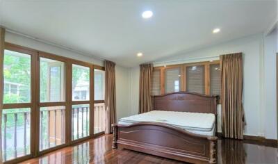 Spacious bedroom with large windows and wooden bed frame