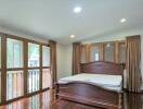 Spacious bedroom with large windows and wooden bed frame