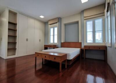 Spacious bedroom with hardwood floors and built-in storage