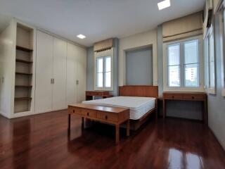 Spacious bedroom with hardwood floors and built-in storage