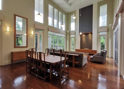 Spacious living room with high ceilings, large windows, and wooden flooring