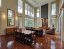 Spacious living room with high ceilings, large windows, and wooden flooring