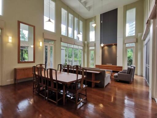 Spacious living room with high ceilings, large windows, and wooden flooring