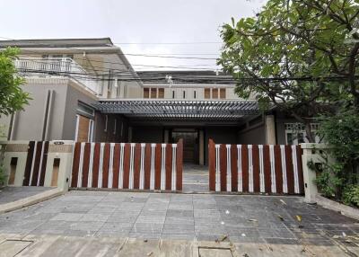 Front exterior of a modern house with a gate and driveway