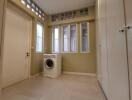 Laundry room with washing machine and ample storage space