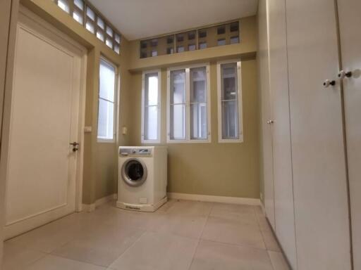 Laundry room with washing machine and ample storage space