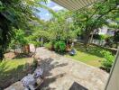 Spacious backyard with greenery and paved area