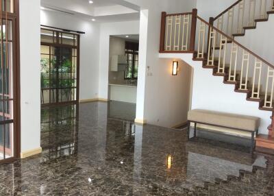 Spacious living room with staircase and large windows