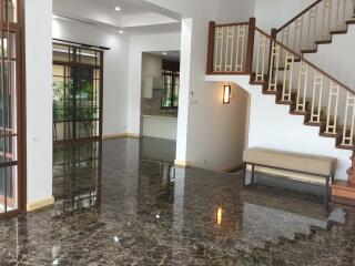 Spacious living room with staircase and large windows