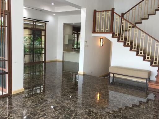 Spacious living room with staircase and large windows