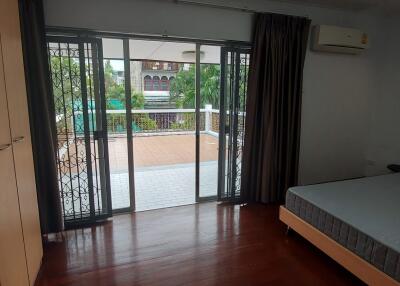 Spacious bedroom with balcony access and outdoor view