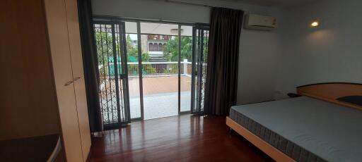 Spacious bedroom with balcony access and outdoor view