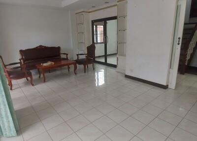 Spacious living room with tile flooring and wooden furniture