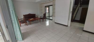 Spacious living room with tile flooring and wooden furniture