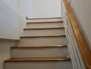 Staircase with wooden steps and white walls