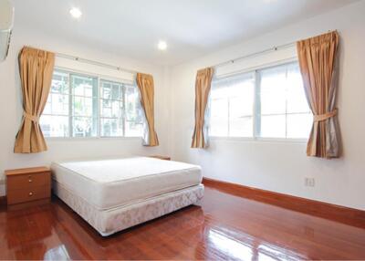 Bright bedroom with wooden flooring and large windows