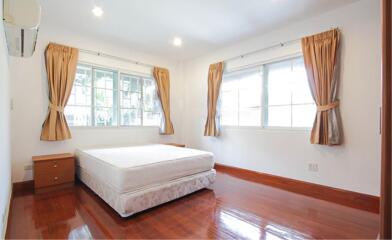 Bright bedroom with wooden flooring and large windows