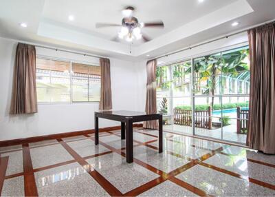 Spacious living room with floor-to-ceiling windows and modern ceiling fan