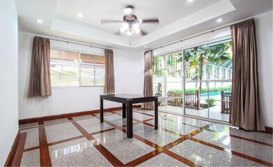 Spacious living room with floor-to-ceiling windows and modern ceiling fan