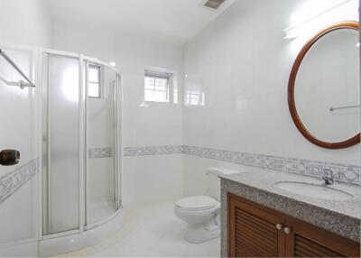 Modern bathroom with a glass-enclosed shower, vanity with mirror, and toilet