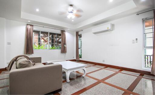 Modern living room with sofa, coffee table, air conditioner, and large window