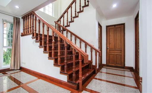 Wooden staircase with polished railing in a bright indoor area