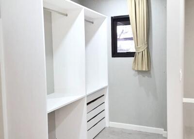 Walk-in closet with built-in shelving and window