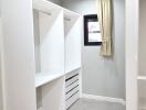 Walk-in closet with built-in shelving and window