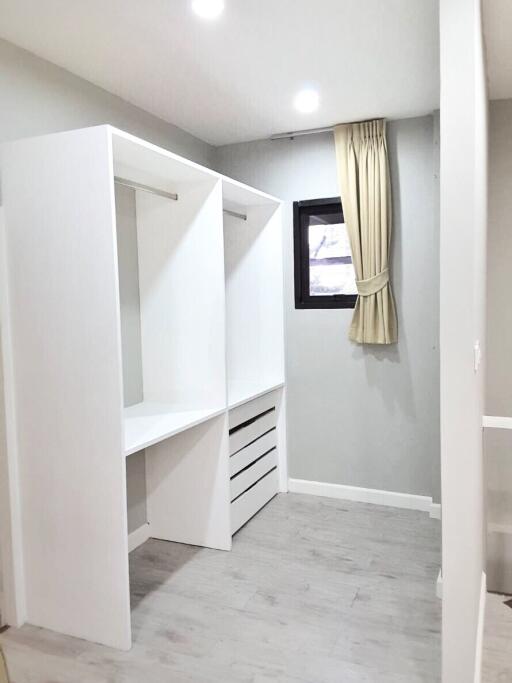 Walk-in closet with built-in shelving and window