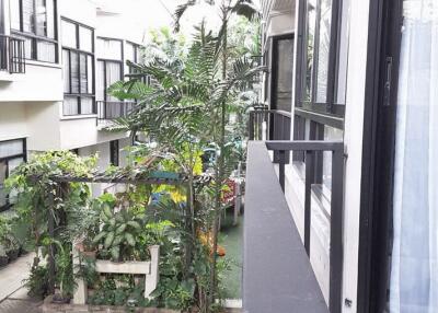 Exterior view of building with balcony and greenery