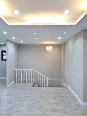 Modern living area with recessed lighting and chandelier