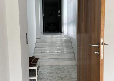 entrance hallway with open wooden door and steps leading to interior