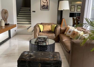 Modern living room with leather sofas, a coffee table, and decorative items