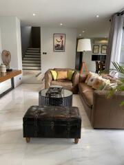 Modern living room with leather sofas, a coffee table, and decorative items