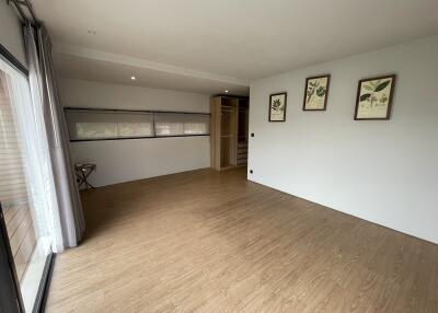 Spacious bedroom with wooden flooring, closet, and wall decorations