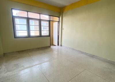 Empty bedroom with large window and tiled floor