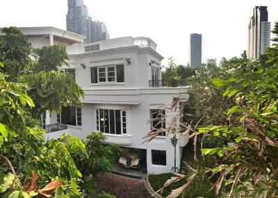 Front view of a two-story house surrounded by greenery