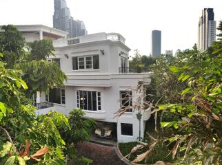 Front view of a two-story house surrounded by greenery