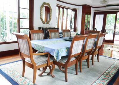 Spacious dining room with wooden furniture and large windows