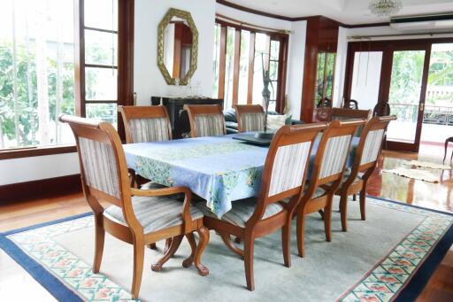 Spacious dining room with wooden furniture and large windows