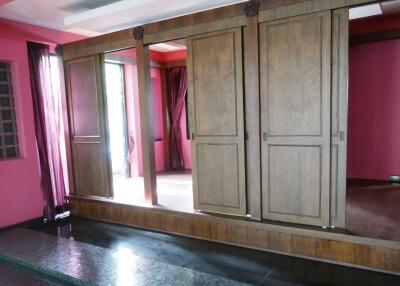 Spacious bedroom with wooden wardrobe and pink accents