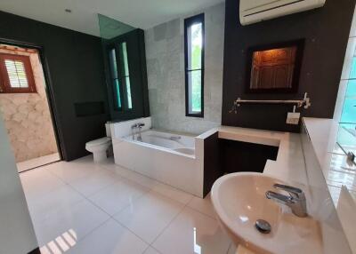 Modern bathroom with bathtub, sink, and air conditioning unit