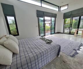 Spacious bedroom with large windows and patio doors