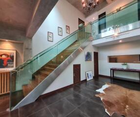 Modern interior with glass railing staircase and artwork