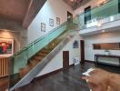 Modern interior with glass railing staircase and artwork