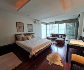 Spacious bedroom with bed, sofa, and work desk