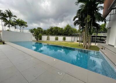 view of a swimming pool with surrounding trees and a patio