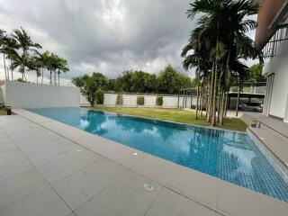 view of a swimming pool with surrounding trees and a patio