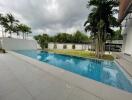 view of a swimming pool with surrounding trees and a patio